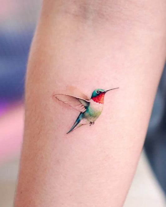 Small Colorful Hummingbird Tattoo on Women Arm by @abii_tattoo