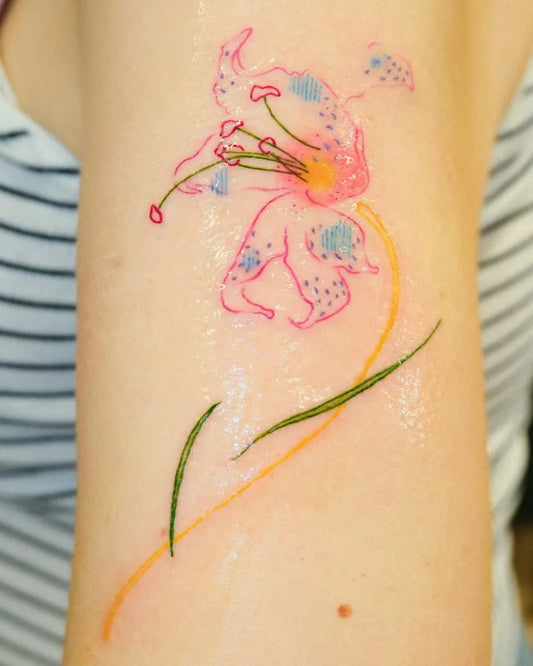Small Colorful Lily Tattoo on Women Arm by @blueymilky.tattoo