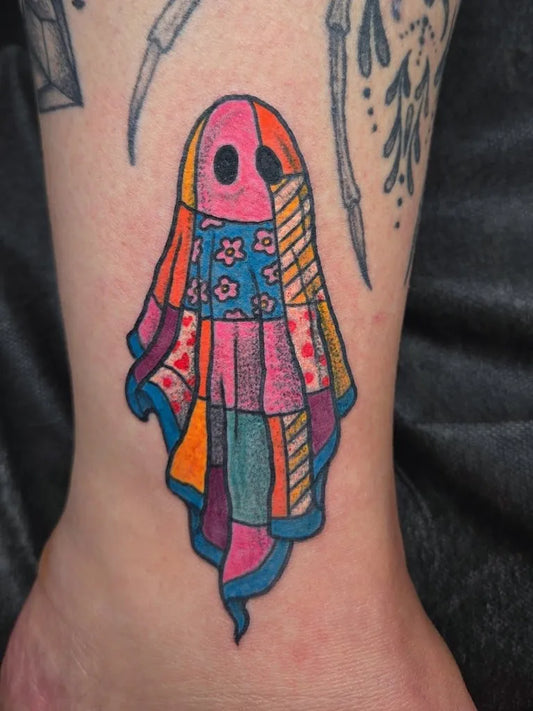 Small Colorwork Ghost Tattoo on Women Ankle by @toughandtendertattoo