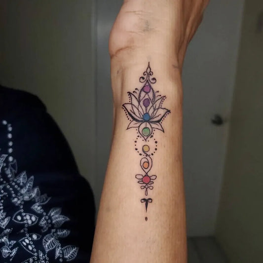 Small Delicate Lotus Flower with Chakra Symbols on Women Wrist Tattoo by @cesarvalerotat