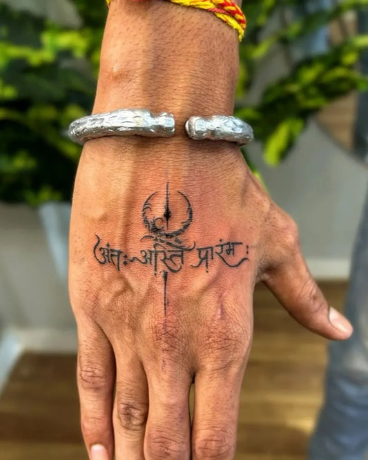 Small Devanagari Script Trishula and Sanskrit Text on Men Hand Tattoo by @indo.ink.tattoo