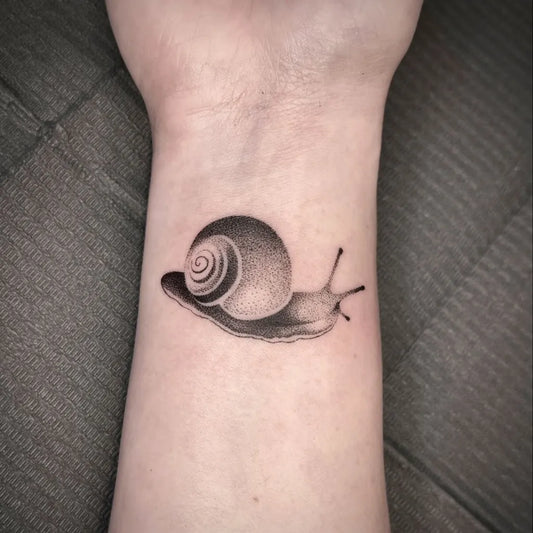 Small Dotwork Snail Tattoo on Women Wrist by @taylor.inks