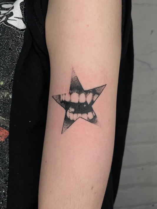 Small Dotwork Star with Teeth Tattoo on Women Arm by @kathrills