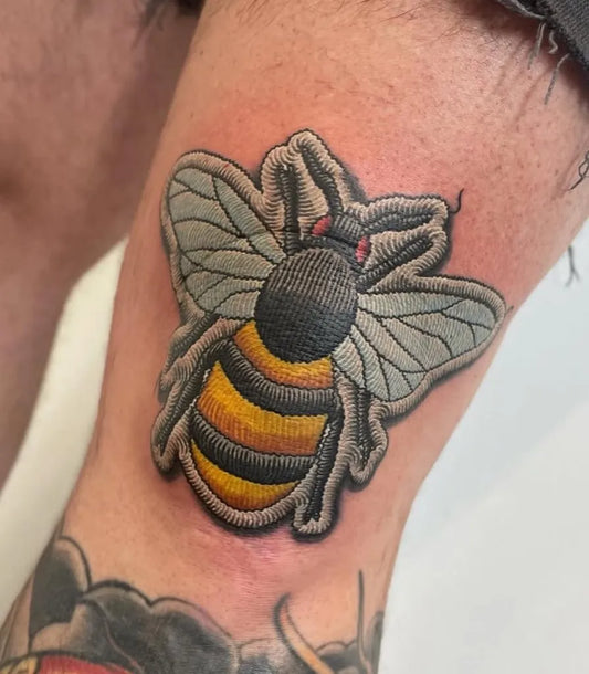 Small Embroidery Bee Tattoo on Men Thigh by @authentink_studio