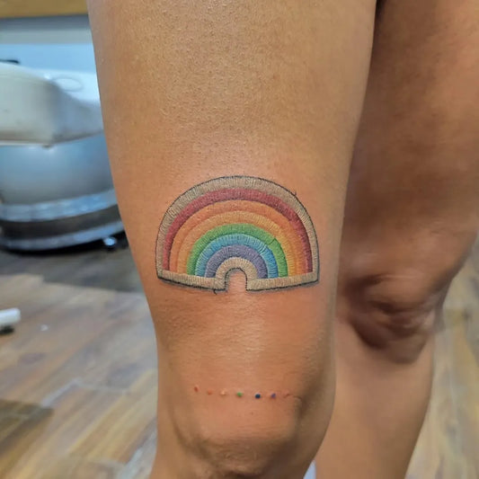 Small Embroidery Rainbow Patch Tattoo on Women Knee by @eyeconictattoos