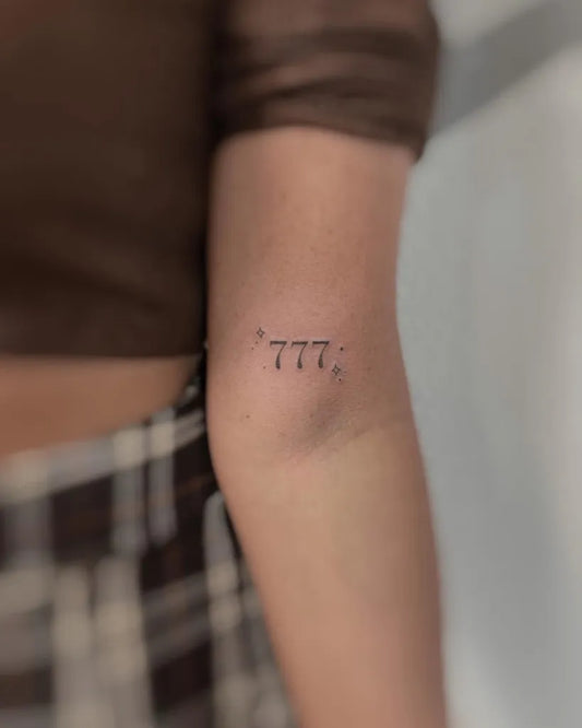 Small Fine Line 777 Tattoo on Women Arm by @kiwi.tattoo.ink