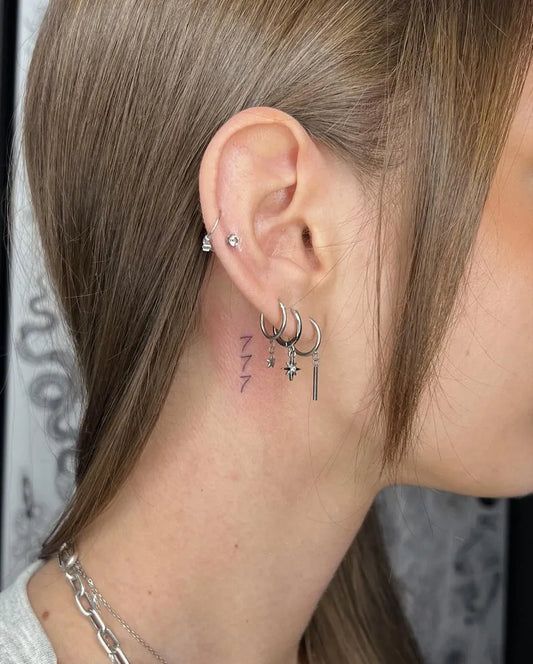 Small Fine Line 777 Tattoo on Women Behind the Ear by @tattoobysashas