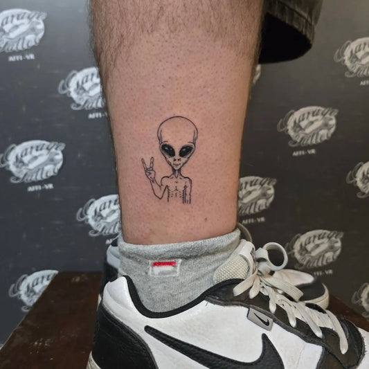 Small Fine Line Alien Tattoo on Men Leg by @charlietatau