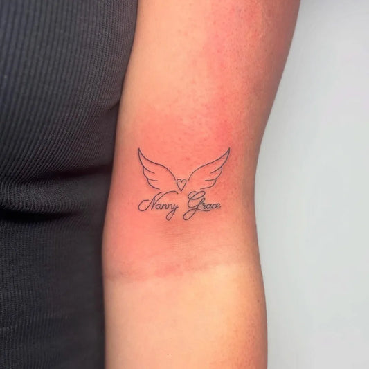 Small Fine Line Angel Wings Nancy Rose Tattoo on Women Arm by @inked.bymolliewilson