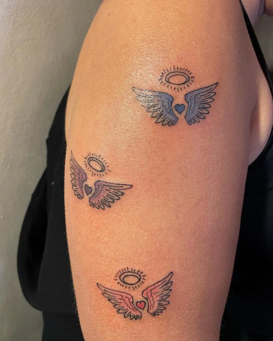 Small Fine Line Angel Wings Tattoo on Women Arm by @red_omen_tattoo
