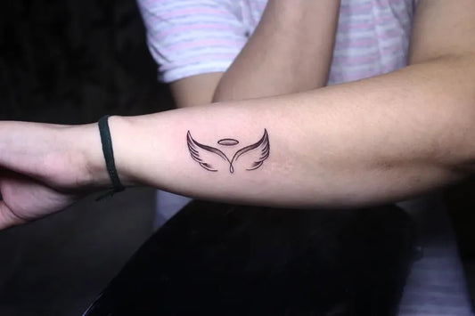 Small Fine Line Angel Wings Tattoo on Women Wrist by @skingrafter