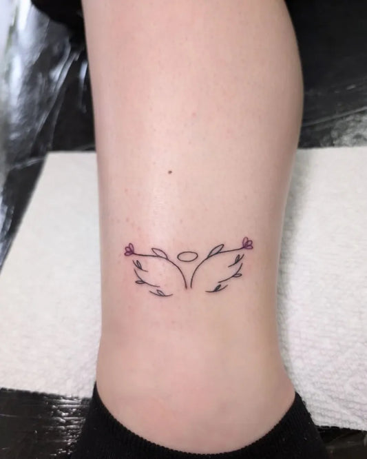 Small Fine Line Angel Wings With Roses and Halo Tattoo on Women Ankle by @eighthelementtattoo