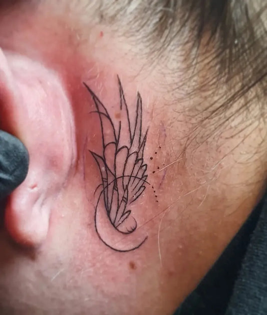 Small Fine Line Angel Wings and Crescent Tattoo on Women Behind the Ear by @damasatattoo