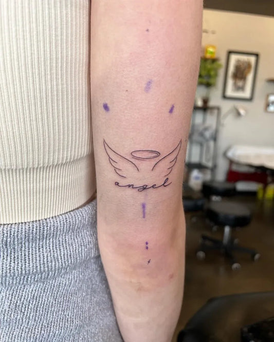 Small Fine Line Angel Wings with Halo Tattoo on Women Upper Arm by @vinny.tattoos