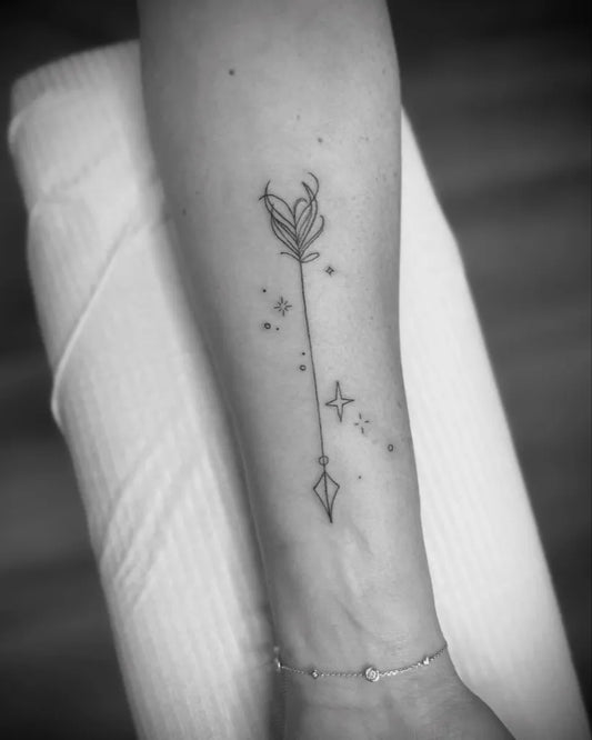Small Fine Line Arrow and Flower Tattoo on Women Wrist by @sereneinksalon