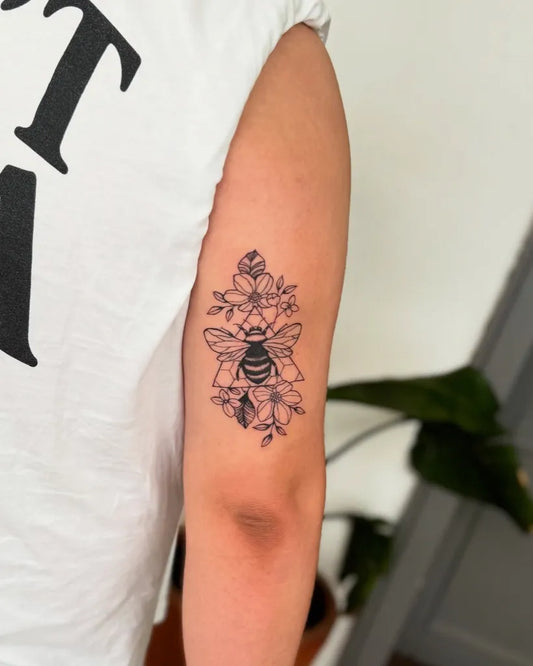Small Fine Line Bee and Flowers on Women Arm Tattoo by @pingalatattoo