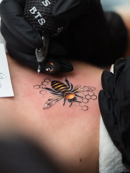 Small Fine Line Bee and Honeycomb on Women Shoulder Tattoo by @sahell.ink