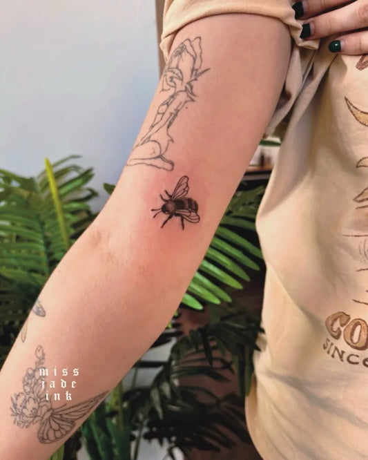 Small Fine Line Bee on Women Arm Tattoo by @missjadeink