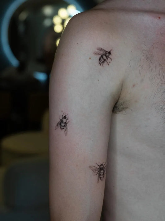 Small Fine Line Bees on Men Arm Tattoo by @mickey.ontheclouds
