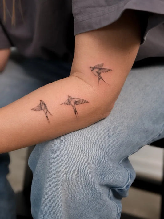 Small Fine Line Birds Tattoo on Women Arm by @piameldgaard_tattoo