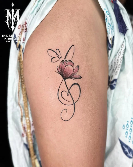 Small Fine Line Butterfly Flower Music Tattoo on Women Upper Arm by @tattoo_ink_majesty_taliparamba
