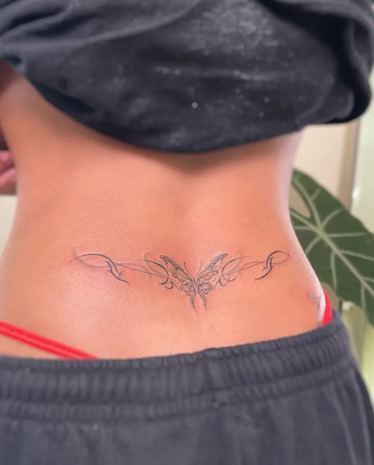 Small Fine Line Butterfly Tattoo on Women Lower Back by @pomaikai.arti