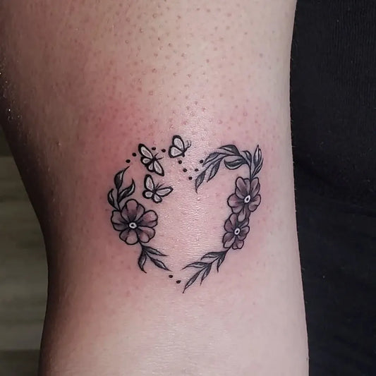 Small Fine Line Butterfly and Flower Heart Tattoo on Women Bicep by @kandikotton