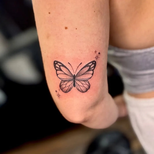Small Fine Line Butterfly and Stars on Women Upper Arm Tattoo by @ink_by_jessrose