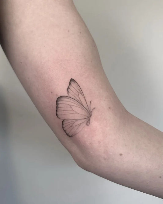 Small Fine Line Butterfly on Women Upper Arm Tattoo by @alisa.ink