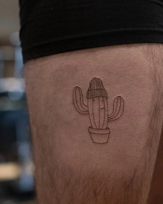 Small Fine Line Cactus with Beanie Tattoo on Men Thigh by @johannamariatattoos