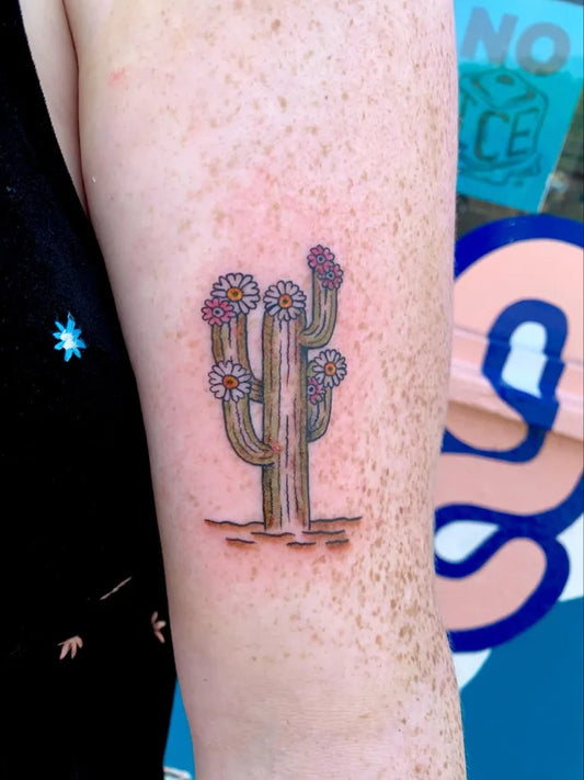 Small Fine Line Cactus with Daisies Tattoo on Women Arm by @charlieboytattoo