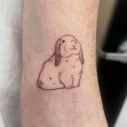 Small Fine Line Cartoon Rabbit Tattoo on Women Forearm by @beastlyflowers