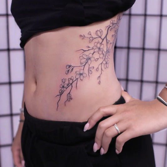 Small Fine Line Cherry Blossom Branch on Women Side Tattoo by @charlotteglatt_tattoos
