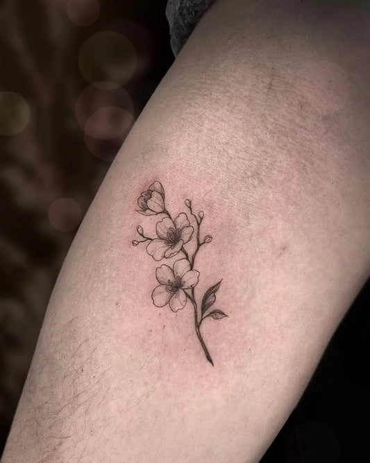 Small Fine Line Cherry Blossom Branch on Women Thigh Tattoo by @jo._.tattoos