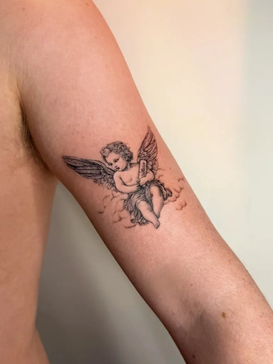 Small Fine Line Cherub Tattoo on Men Arm by @hansytattoos