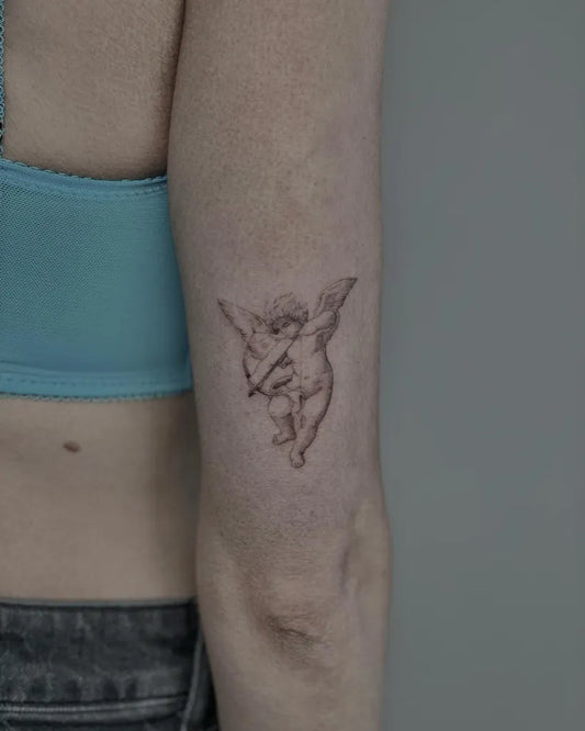 Small Fine Line Cherub Tattoo on Women Arm by @defneink