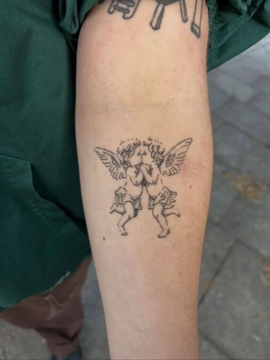 Small Fine Line Cherub Tattoo on Women Arm by @segadoeslines