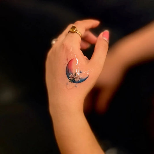 Small Fine Line Color Moon and Daisies Tattoo on Women Hand by @rinktattooz