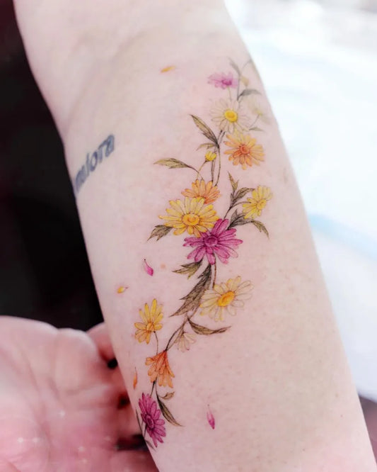 Small Fine Line Colorful Daisy Flowers Tattoo on Women Arm by @cheeu_tattoo