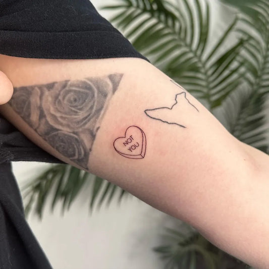 Small Fine Line Conversation Heart Wolf Silhouette Roses Tattoo on Women Bicep by @inkedby.chlo