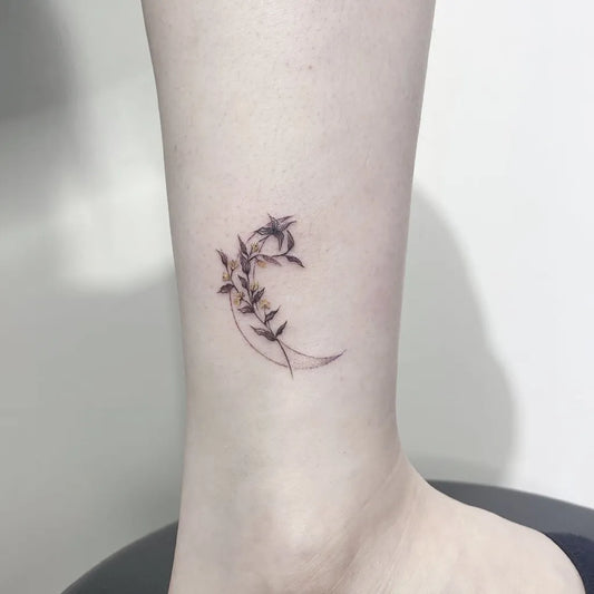 Small Fine Line Crescent Moon and Leaves Tattoo on Women Ankle by @tattoogo_studio