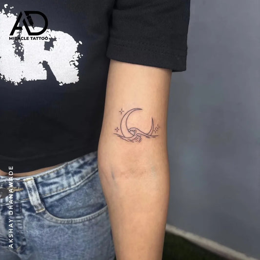 Small Fine Line Crescent Moon and Wave Tattoo on Women Arm by @ad_miracle_tattoos