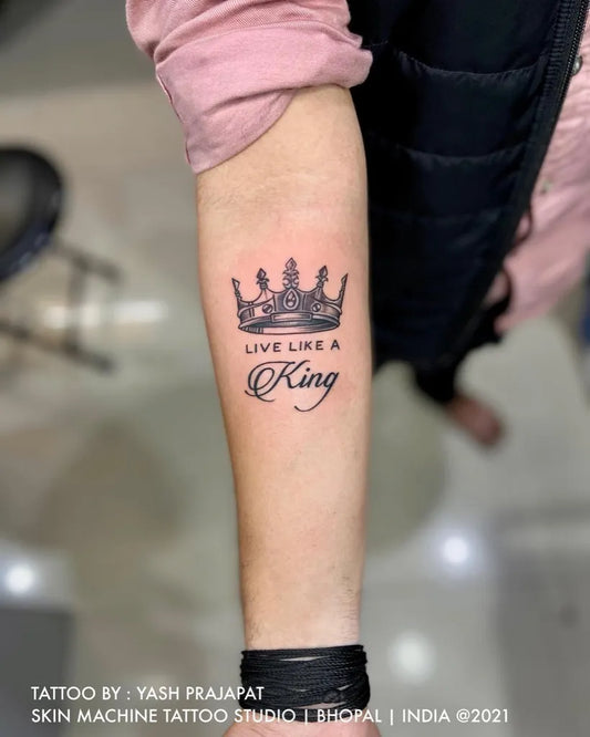Small Fine Line Crown and Text Tattoo on Women Forearm by @skinmachinetattoo