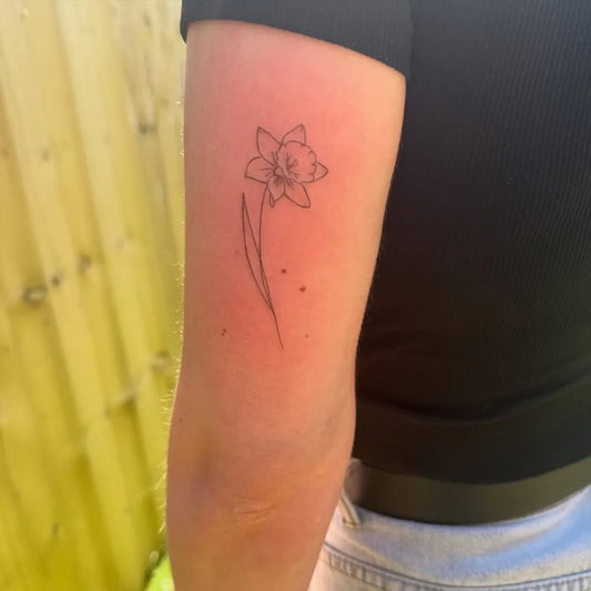 Small Fine Line Daffodil Tattoo on Women Arm by @dinkytattoocardiff