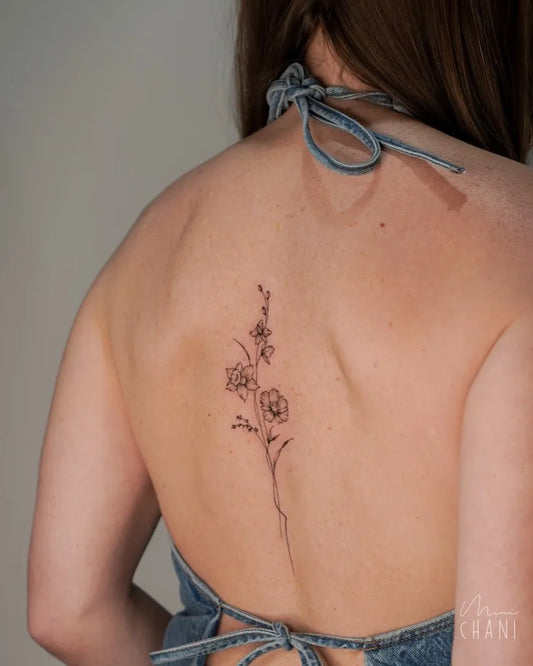 Small Fine Line Daffodil Tattoo on Women Back by @mini.chani