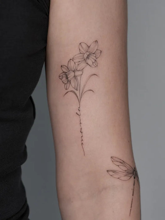 Small Fine Line Daffodil and Dragonfly Tattoo on Women Arm by @julia.hei.tattoo