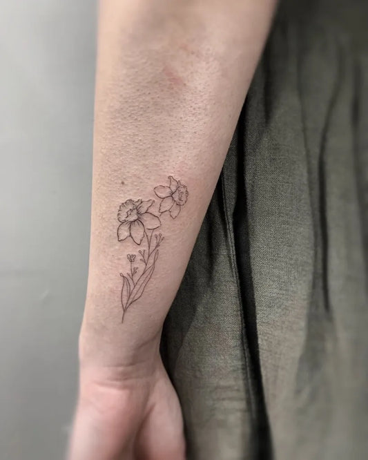 Small Fine Line Daffodils Tattoo on Women Wrist by @finelinetattooslondon