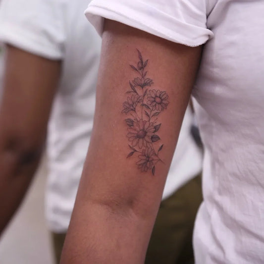 Small Fine Line Daisy Flowers Tattoo on Women Arm by @charlotteglatt_tattoos