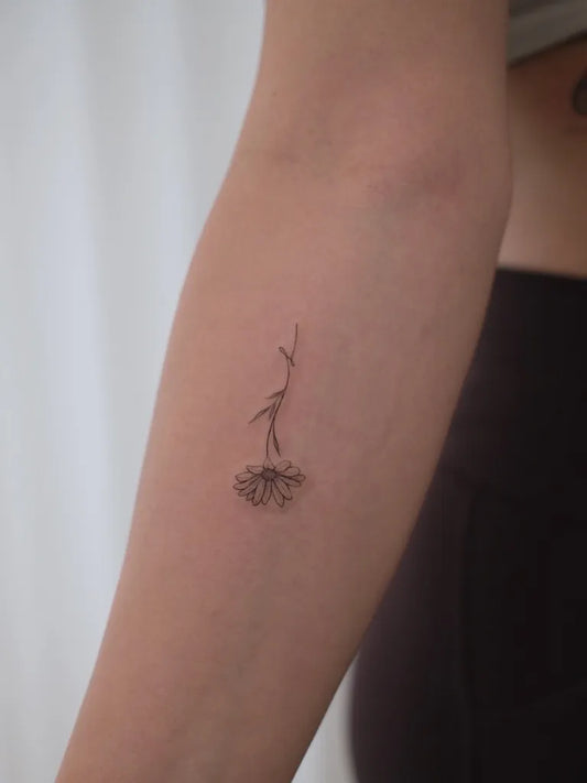 Small Fine Line Daisy Tattoo on Women Arm by @keepgrowing.art