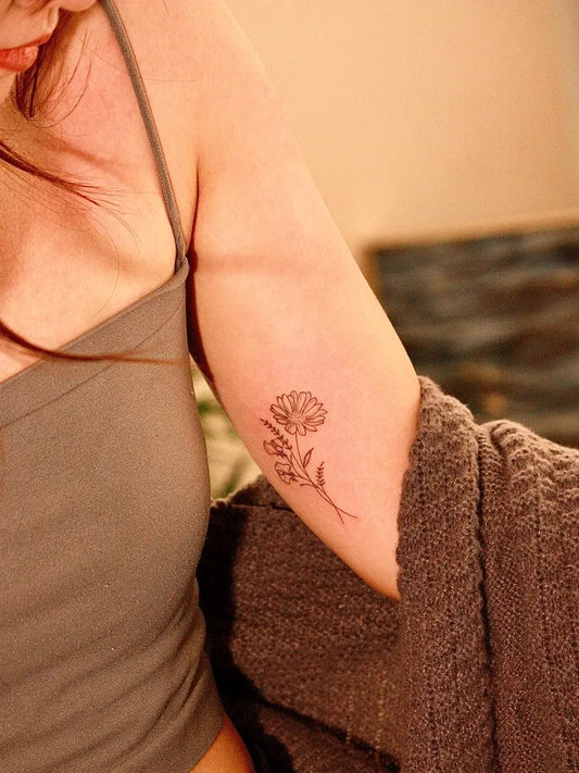 Small Fine Line Daisy Tattoo on Women Arm by @won_tattooer